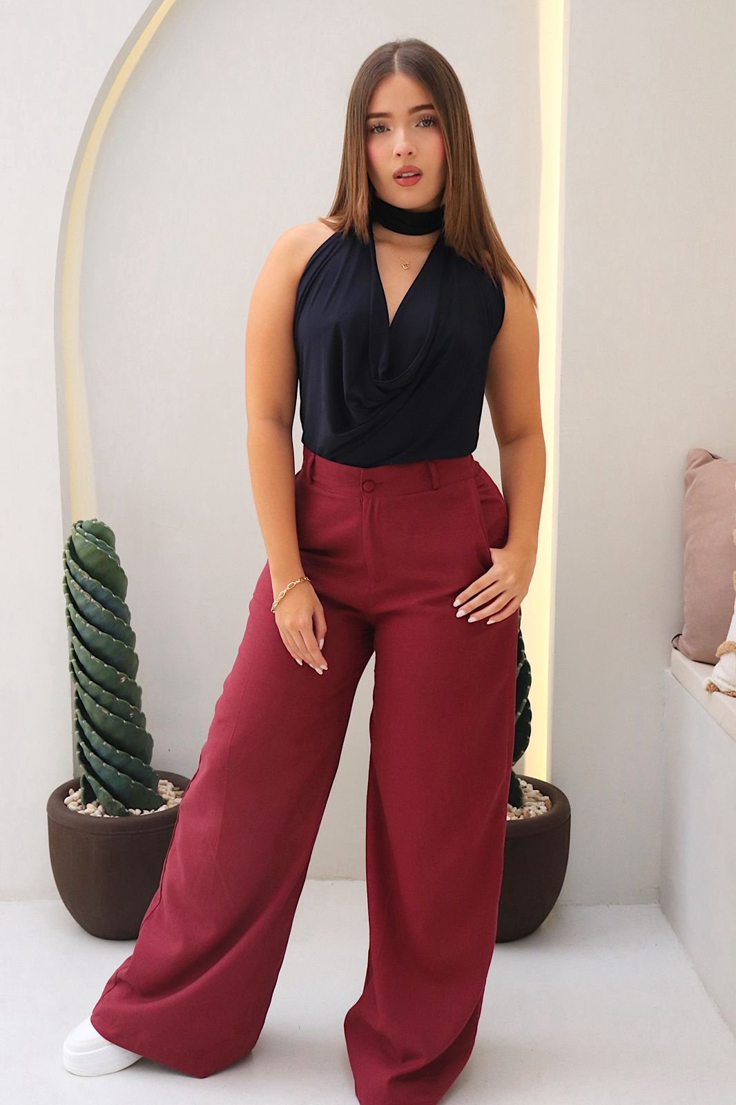 Blusa Aria en acetato doble tela, con diseño drapeado, tira al cuello y detalle de realce en el escote. Disponible en tallas S y M.