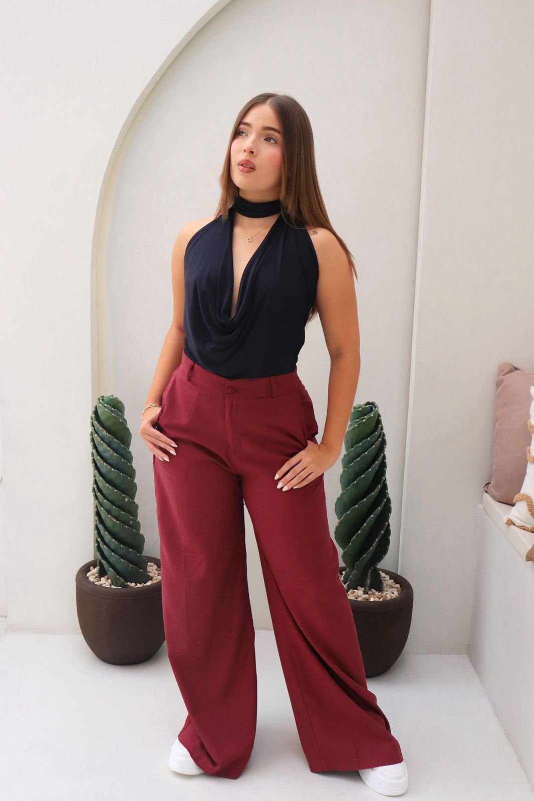 Blusa Aria en acetato doble tela, con diseño drapeado, tira al cuello y detalle de realce en el escote. Disponible en tallas S y M.