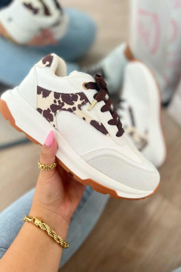 Tenis Amalia Cow en blanco con detalles en beige y gamuza estampada de vaca tono mocca, estilo sport elegante.