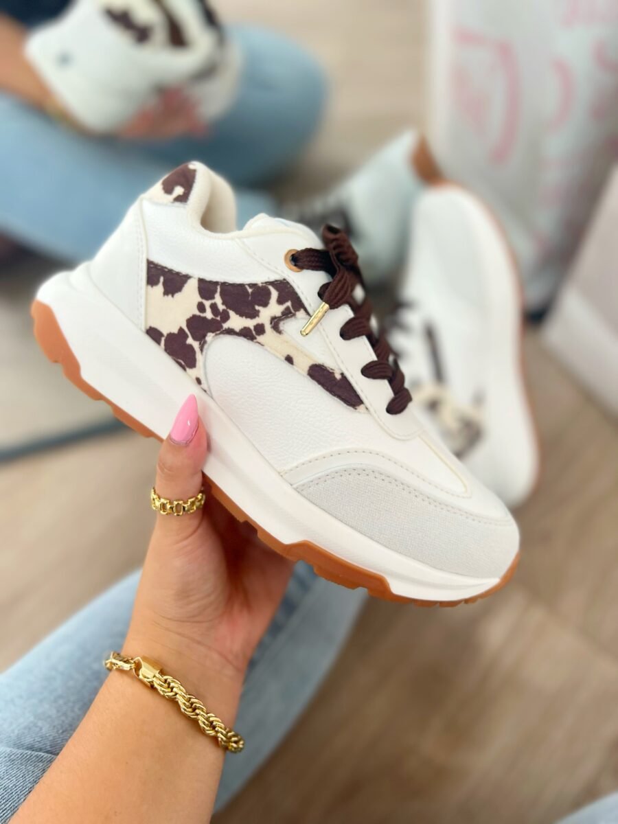 Tenis Amalia Cow en blanco con detalles en beige y gamuza estampada de vaca tono mocca, estilo sport elegante.