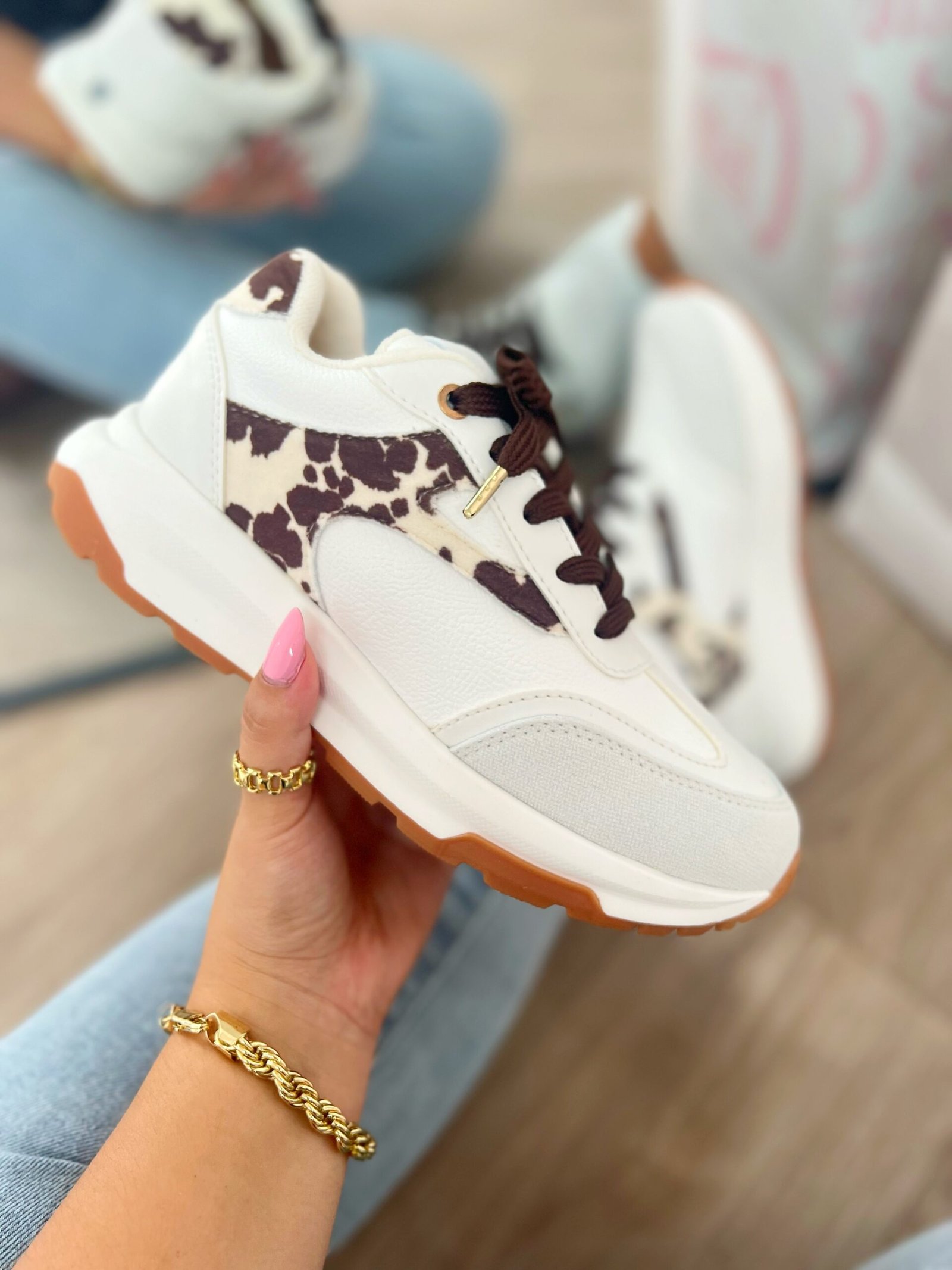 Tenis Amalia Cow en blanco con detalles en beige y gamuza estampada de vaca tono mocca, estilo sport elegante.