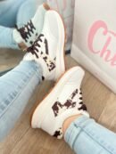 Tenis Amalia Cow en blanco con detalles en beige y gamuza estampada de vaca tono mocca, estilo sport elegante.