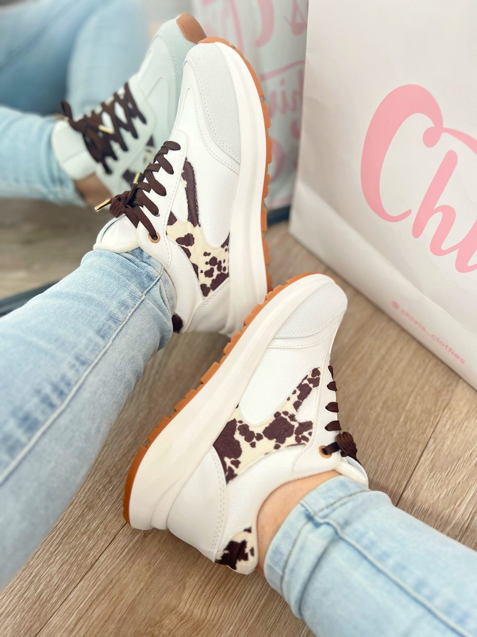 Tenis Amalia Cow en blanco con detalles en beige y gamuza estampada de vaca tono mocca, estilo sport elegante.