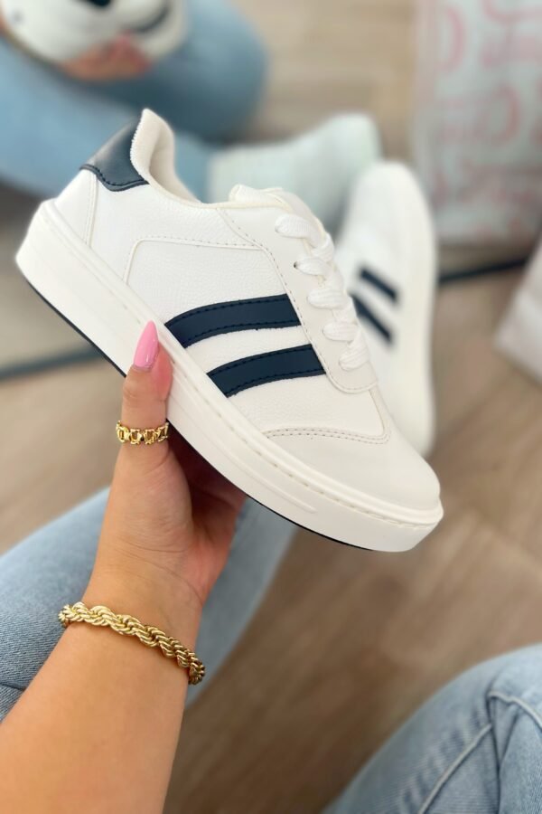 Tenis Santa blancos con líneas negro y punta en gamuza, estilo versátil y cómodo.