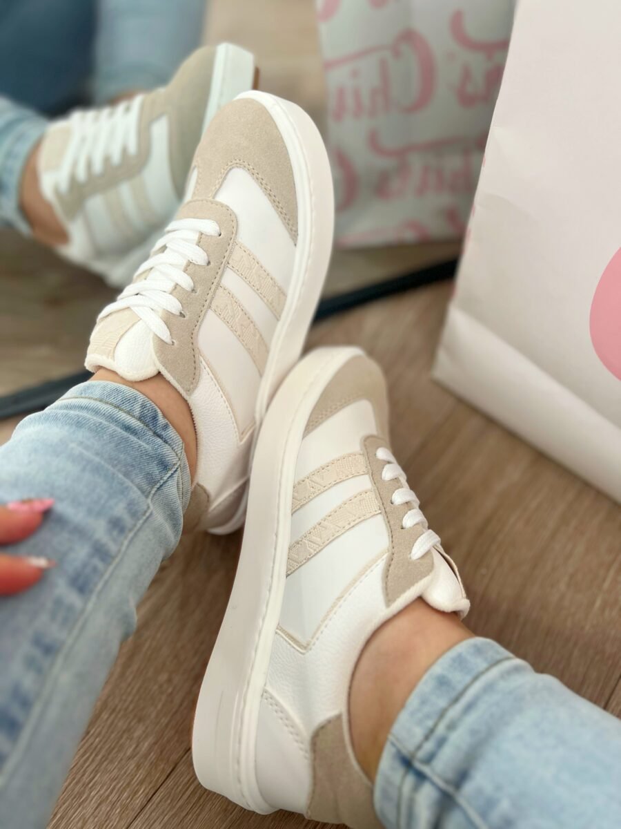 Tenis Santa Nude en tono blanco talco con detalles nude en acabado charolado y líneas en relieve, estilo versátil y moderno.