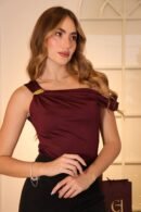 Blusa Tessa en acetato de doble tela con caída drapeada en los hombros, escote medio beso y detalle de hebilla lateral.