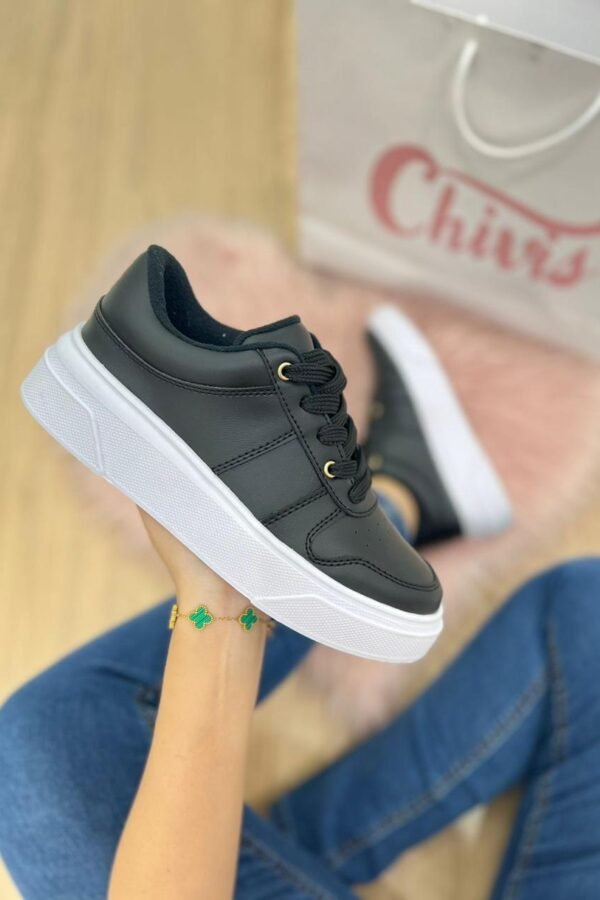 Tenis negros de suela baja con diseño cómodo y detalle dorado decorativo en la zona de los cordones.