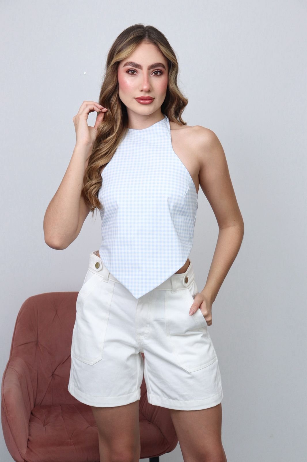 Blusa de diseño halter con escote alto que estiliza los hombros y realza la silueta.