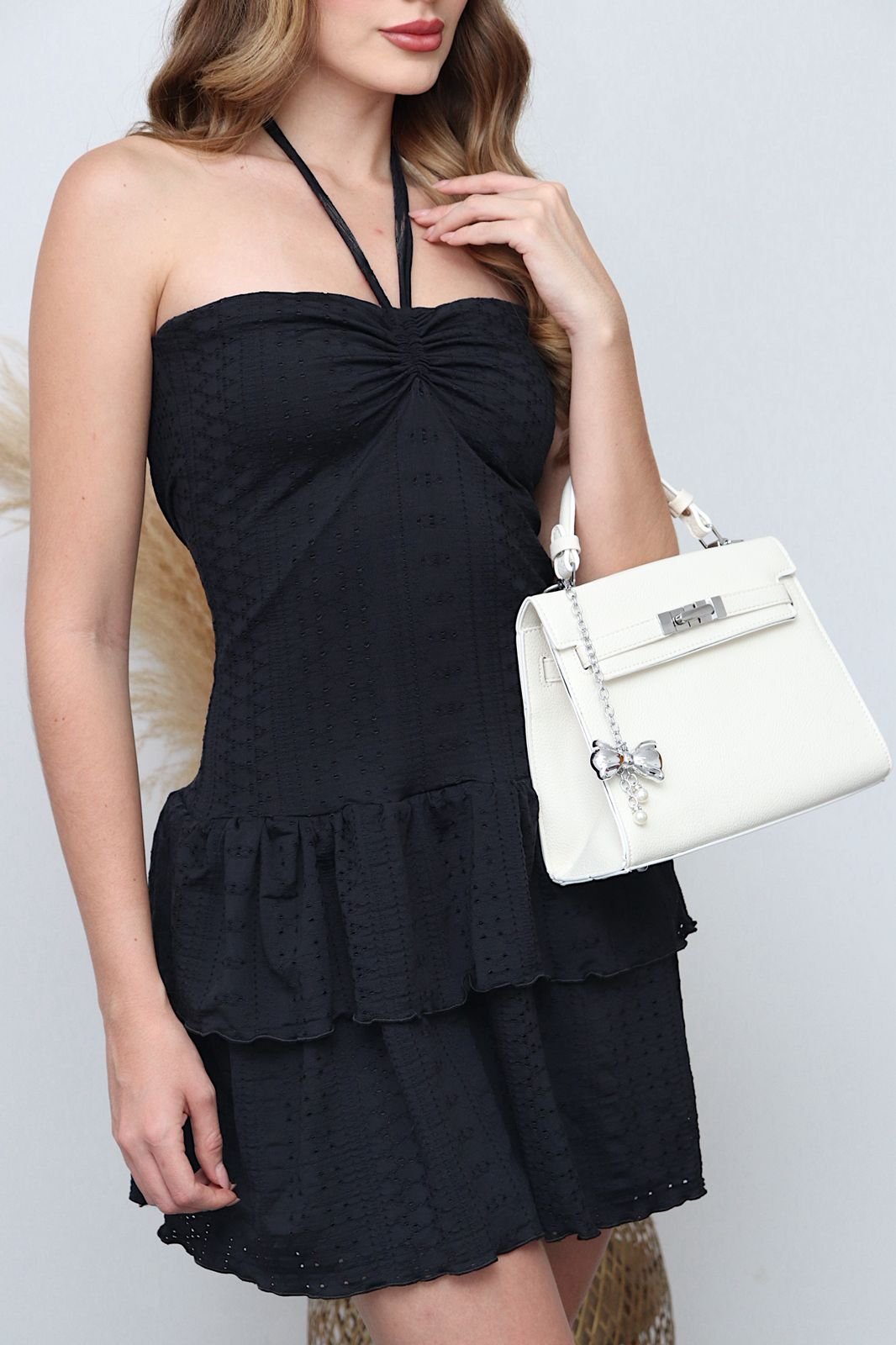 Vestido en tela ojalillo con diseño halter que realza los hombros y estiliza la silueta.