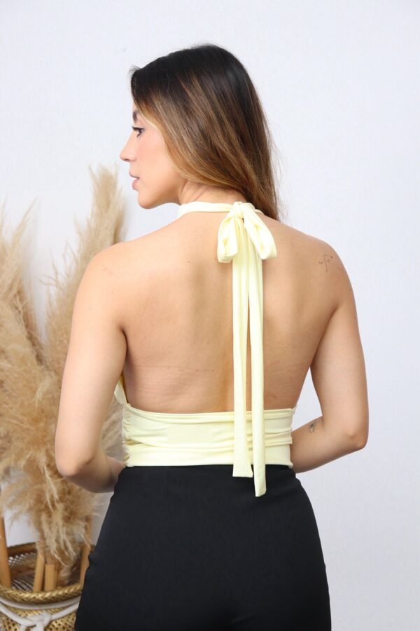 La Blusa Sole destaca por su diseño sofisticado y femenino, con cuello halter que estiliza los hombros y una silueta delicadamente drapeada que aporta movimiento y elegancia.