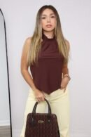 Su silueta asimétrica y detalle metálico hacen de esta blusa una pieza única y sofisticada.